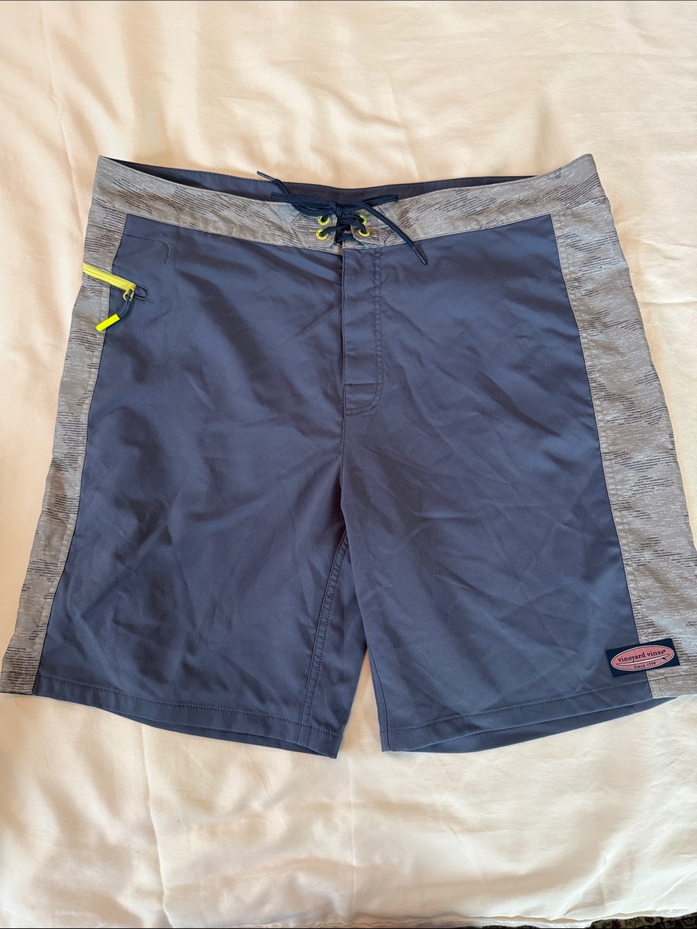 Vineyard Vines Navy & Heather Gray Men’s Board Shorts with Yellow zip pocket.